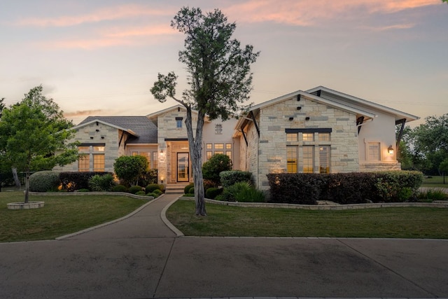 view of front of home with a front lawn and stone siding