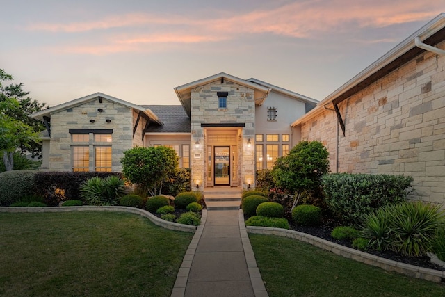 view of front of home with a front yard and stone siding