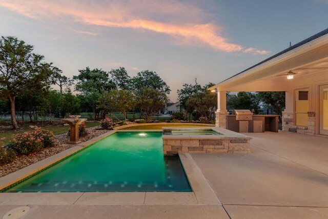 outdoor pool with a patio, an in ground hot tub, exterior kitchen, and grilling area