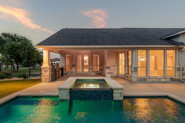 back of property featuring exterior kitchen, a fenced in pool, fence, and a patio area