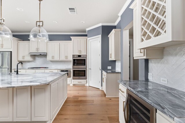 kitchen featuring backsplash, visible vents, crown molding, wine cooler, and stainless steel appliances