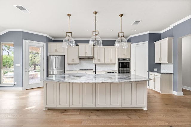 2120 High Lonesome Dr, Leander, TX 78641 - kitchen featuring stainless steel appliances, a large island with sink, backsplash, light wood finished floors, and white cabinets