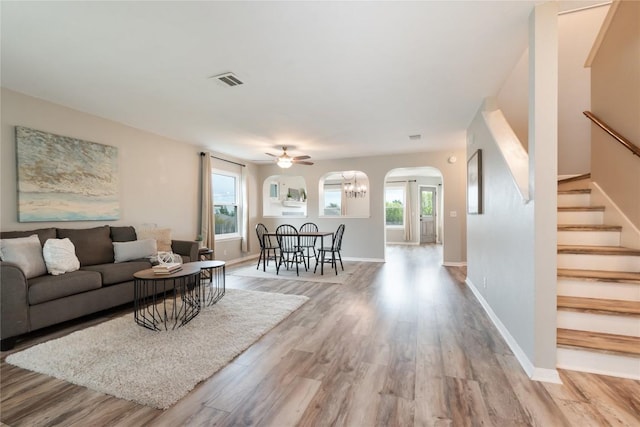 234 Saint Marys Dr, Hutto, TX 78634 - living area with visible vents, arched walkways, light wood finished floors, and stairs
