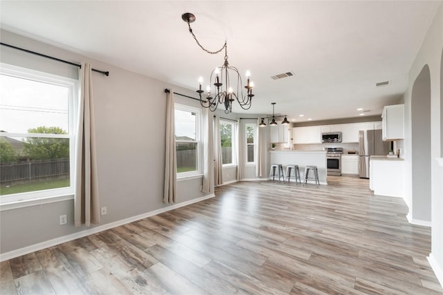234 Saint Marys Dr, Hutto, TX 78634 - unfurnished living room featuring visible vents, baseboards, a chandelier, light wood-style floors, and recessed lighting