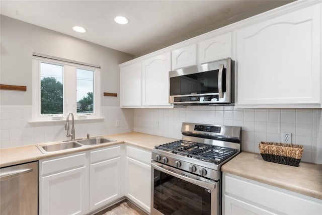 234 Saint Marys Dr, Hutto, TX 78634 - kitchen with white cabinetry, appliances with stainless steel finishes, a sink, and tasteful backsplash