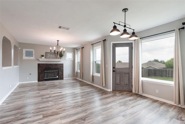 234 Saint Marys Dr, Hutto, TX 78634 - interior space with visible vents, a high end fireplace, wood finished floors, baseboards, and an inviting chandelier