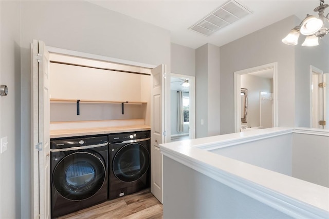 234 Saint Marys Dr, Hutto, TX 78634 - clothes washing area with separate washer and dryer, laundry area, visible vents, and light wood-style floors