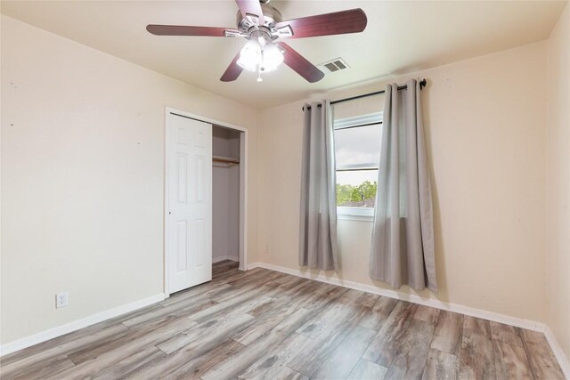 234 Saint Marys Dr, Hutto, TX 78634 - unfurnished bedroom with a ceiling fan, visible vents, wood finished floors, baseboards, and a closet