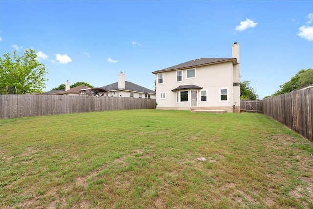 234 Saint Marys Dr, Hutto, TX 78634 - back of house with a fenced backyard, stucco siding, a yard, and a chimney