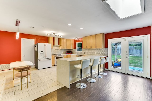 11600 Eubank Dr, Austin, TX 78758 - kitchen featuring white fridge with ice dispenser, stainless steel stove, a peninsula, a breakfast bar area, and light countertops