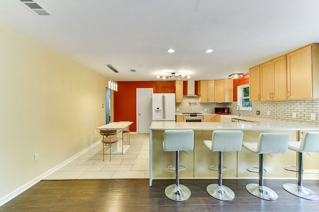 11600 Eubank Dr, Austin, TX 78758 - kitchen with white refrigerator with ice dispenser, a peninsula, light countertops, tasteful backsplash, and a kitchen breakfast bar