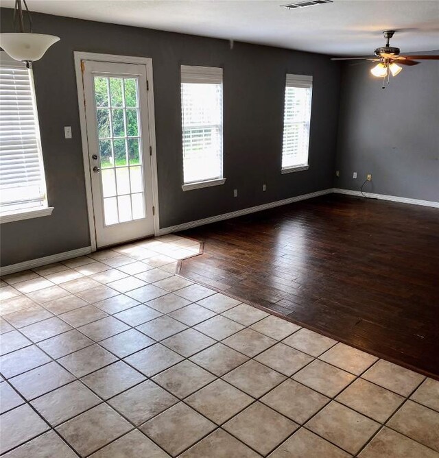 doorway to outside with baseboards, visible vents, ceiling fan, and light wood-style floors
