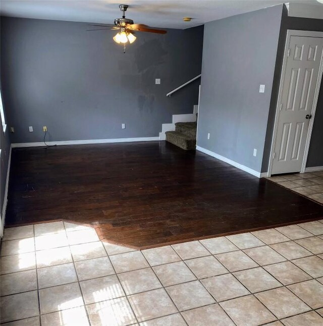 interior space featuring stairway, baseboards, ceiling fan, and wood finished floors