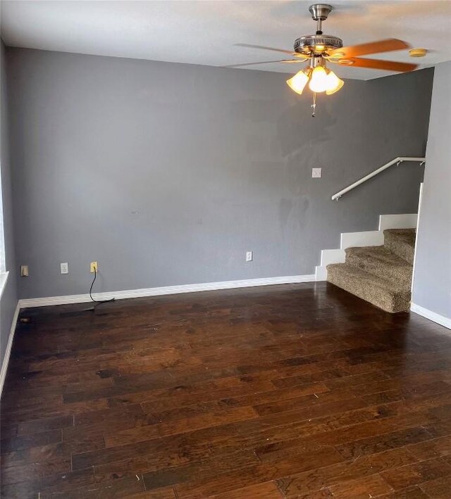 interior space with baseboards, a ceiling fan, stairs, and wood finished floors