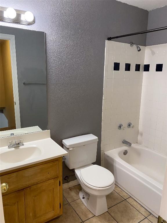 619 Ellen Ct, Temple, TX 76501 - bathroom featuring a textured wall, toilet, tile patterned flooring, vanity, and washtub / shower combination