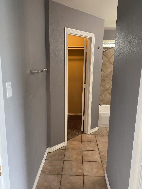 hall with tile patterned floors and baseboards