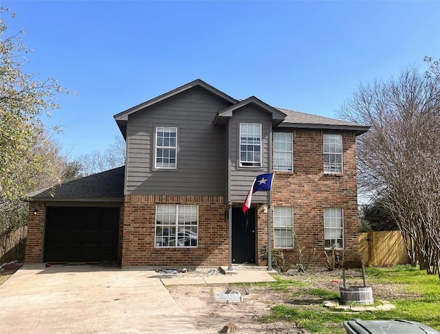 traditional home with brick siding, a garage, fence, and concrete driveway