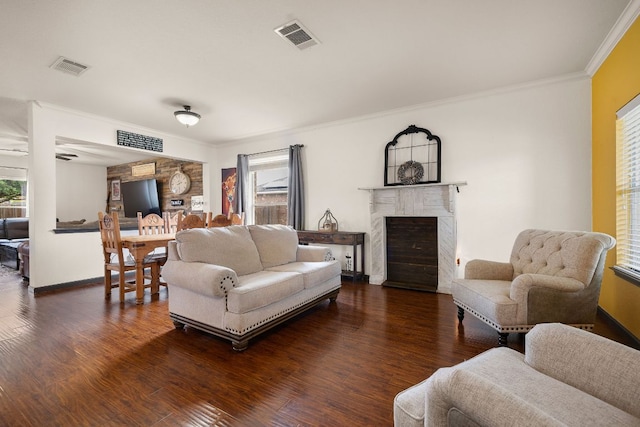living area with ornamental molding, wood finished floors, and visible vents