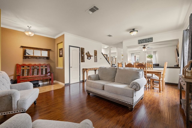 living area featuring crown molding, visible vents, and wood finished floors