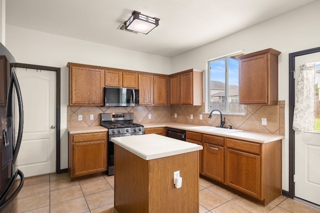 12616 Wayne Spur Ln, Elgin, TX 78621 - kitchen featuring black appliances, a sink, a center island, tasteful backsplash, and light countertops