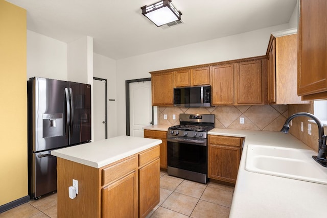 12616 Wayne Spur Ln, Elgin, TX 78621 - kitchen with appliances with stainless steel finishes, a sink, light tile patterned floors, decorative backsplash, and light countertops