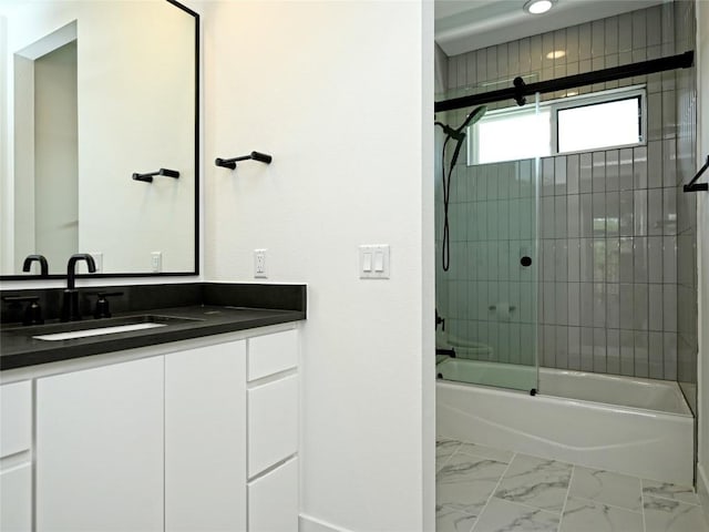 bathroom featuring vanity, bath / shower combo with glass door, marble finish floor, and baseboards