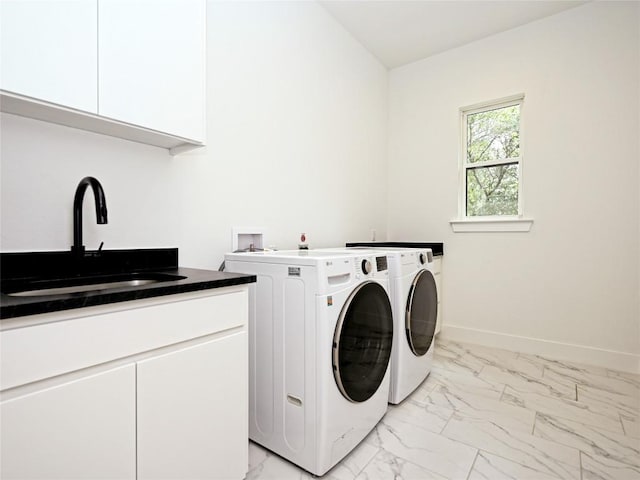 laundry area with cabinet space, washer and clothes dryer, a sink, and marble finish floor