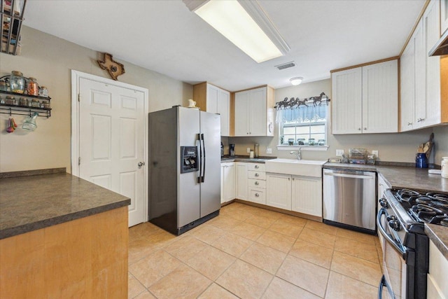 2334 County Road 464, Elgin, TX 78621 - kitchen featuring visible vents, dark countertops, appliances with stainless steel finishes, light tile patterned floors, and a sink