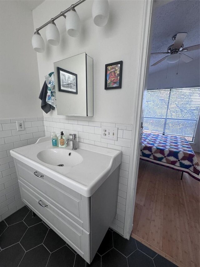 bathroom with tile patterned floors, tile walls, and a wainscoted wall