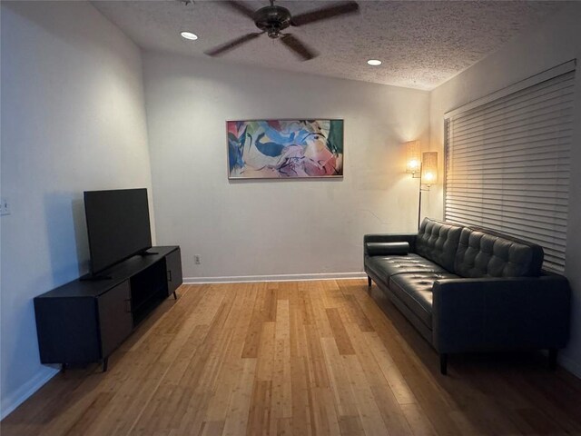 living area featuring baseboards, ceiling fan, recessed lighting, a textured ceiling, and light wood finished floors