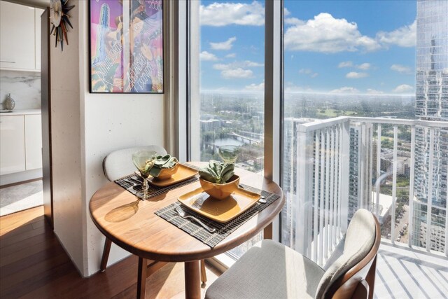 dining room with a city view, wood finished floors, and a healthy amount of sunlight