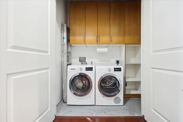 clothes washing area with cabinet space and washing machine and dryer