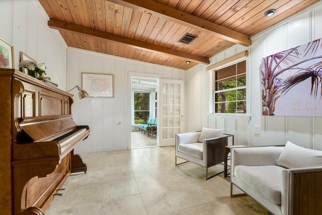 sitting room with beamed ceiling, visible vents, wood ceiling, and a decorative wall