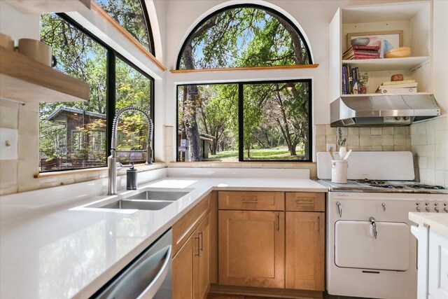 kitchen with decorative backsplash, open shelves, light countertops, a sink, and under cabinet range hood