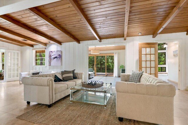 living area with visible vents, tile patterned floors, beam ceiling, and wooden ceiling