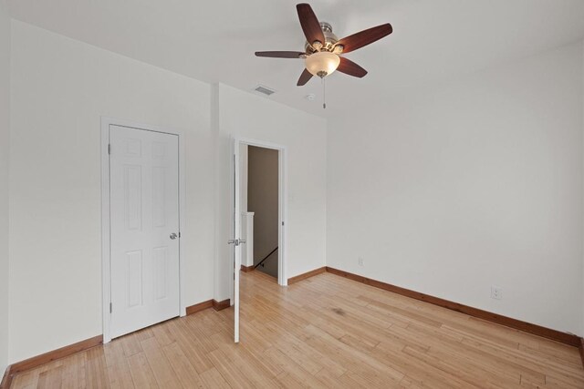 unfurnished bedroom with light wood-style floors, baseboards, a ceiling fan, and visible vents