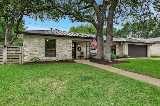 view of front facade with fence, an attached garage, a front lawn, stone siding, and a standing seam roof