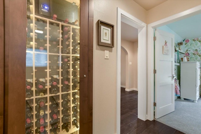 wine room featuring arched walkways and wood finished floors