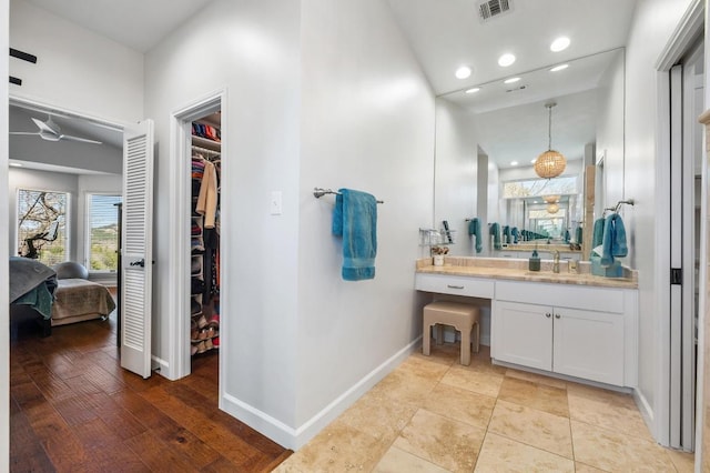 3605 Fawn Creek Path, Austin, TX 78746 - bathroom with vanity, a spacious closet, recessed lighting, connected bathroom, and a ceiling fan