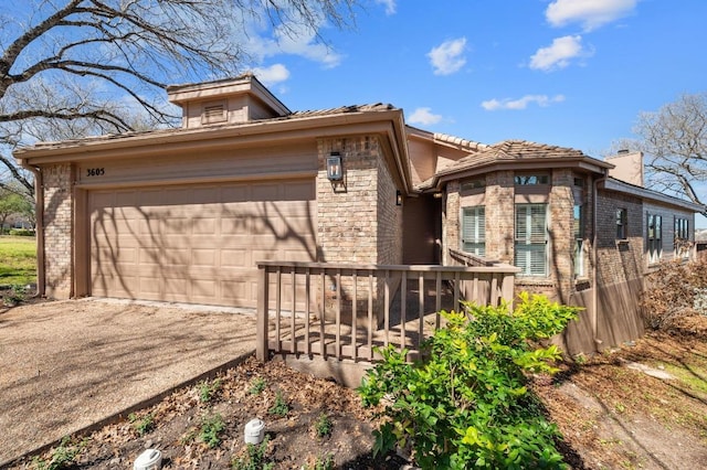 3605 Fawn Creek Path, Austin, TX 78746 - view of front of home featuring brick siding, driveway, an attached garage, a chimney, and a tiled roof