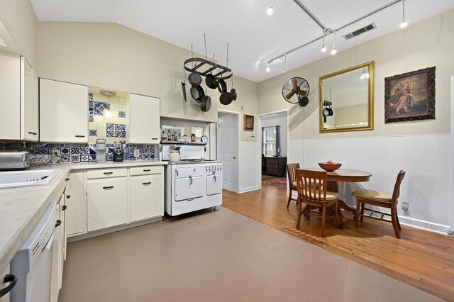 kitchen featuring white appliances, light countertops, white cabinetry, and a wainscoted wall