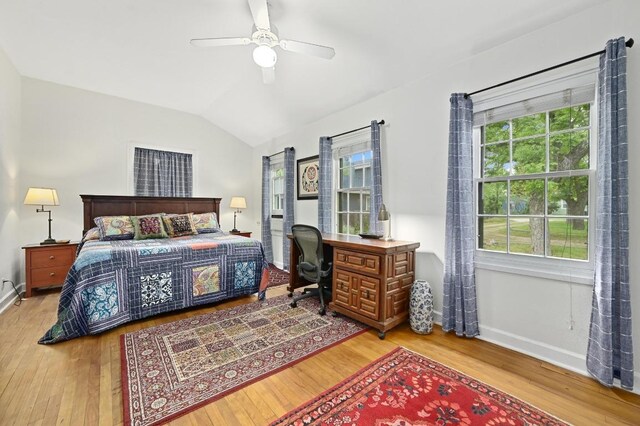 bedroom featuring baseboards, ceiling fan, wood finished floors, and lofted ceiling