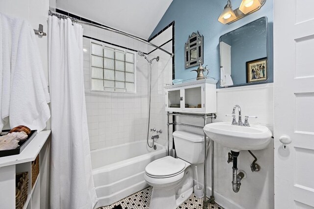 full bathroom with shower / bath combination with curtain, toilet, and lofted ceiling