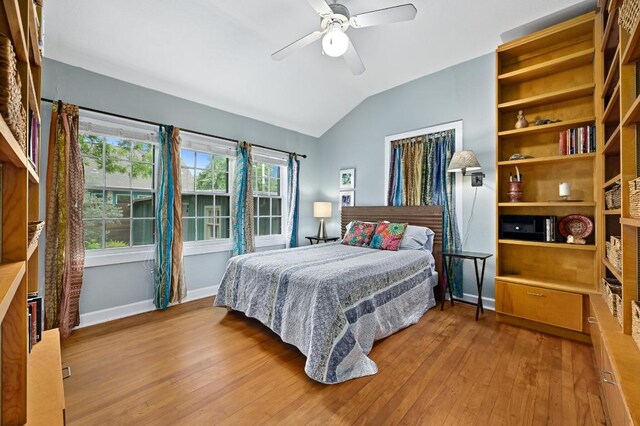 bedroom featuring baseboards, ceiling fan, hardwood / wood-style flooring, and lofted ceiling