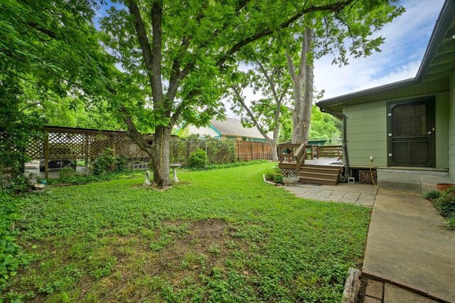view of yard featuring a fenced backyard, a patio area, and a wooden deck