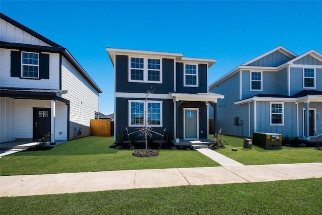traditional-style home with fence, central AC unit, board and batten siding, and a front lawn