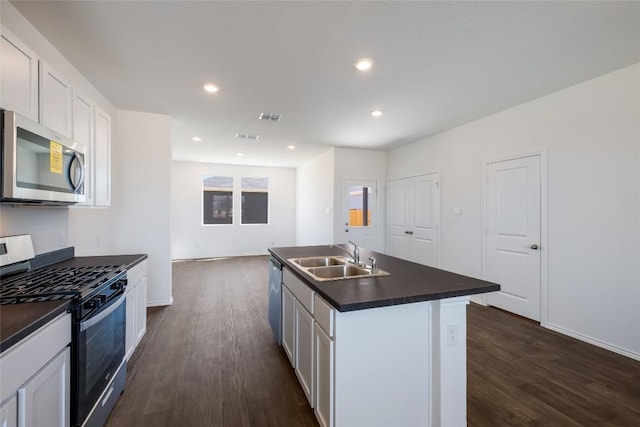 kitchen featuring a sink, dark wood-style flooring, appliances with stainless steel finishes, and dark countertops