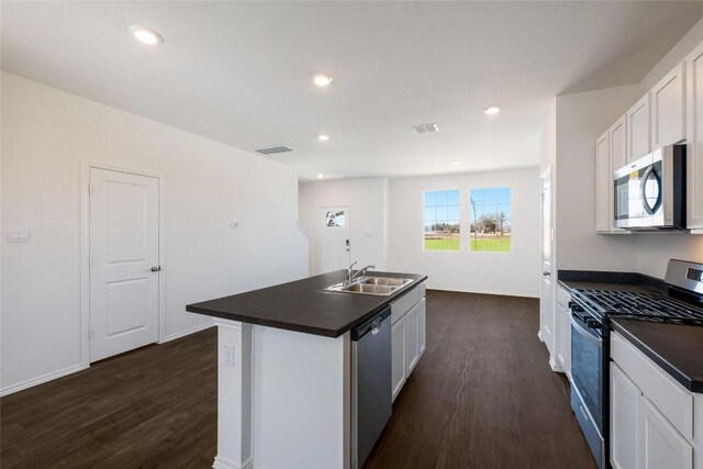 kitchen featuring a sink, dark countertops, stainless steel appliances, and dark wood-style floors