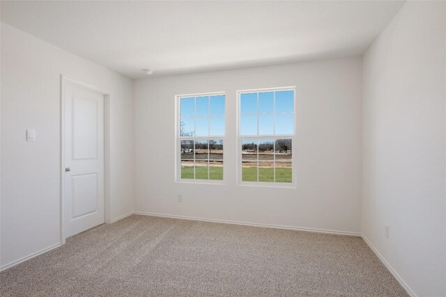 carpeted empty room with baseboards