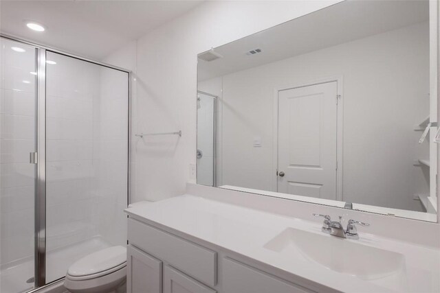 full bathroom featuring toilet, visible vents, a shower stall, and vanity